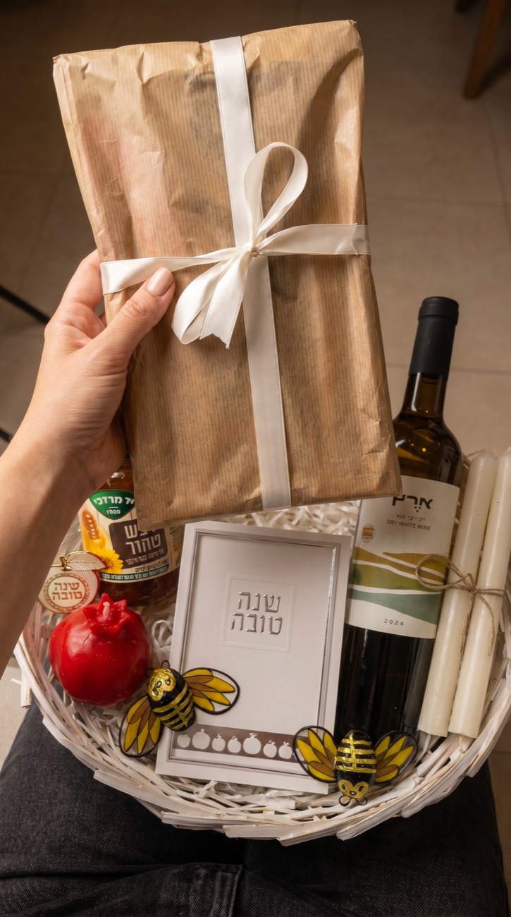 יד מציגה את קופסת הרוגלך העטופה ממארז ראש השנה